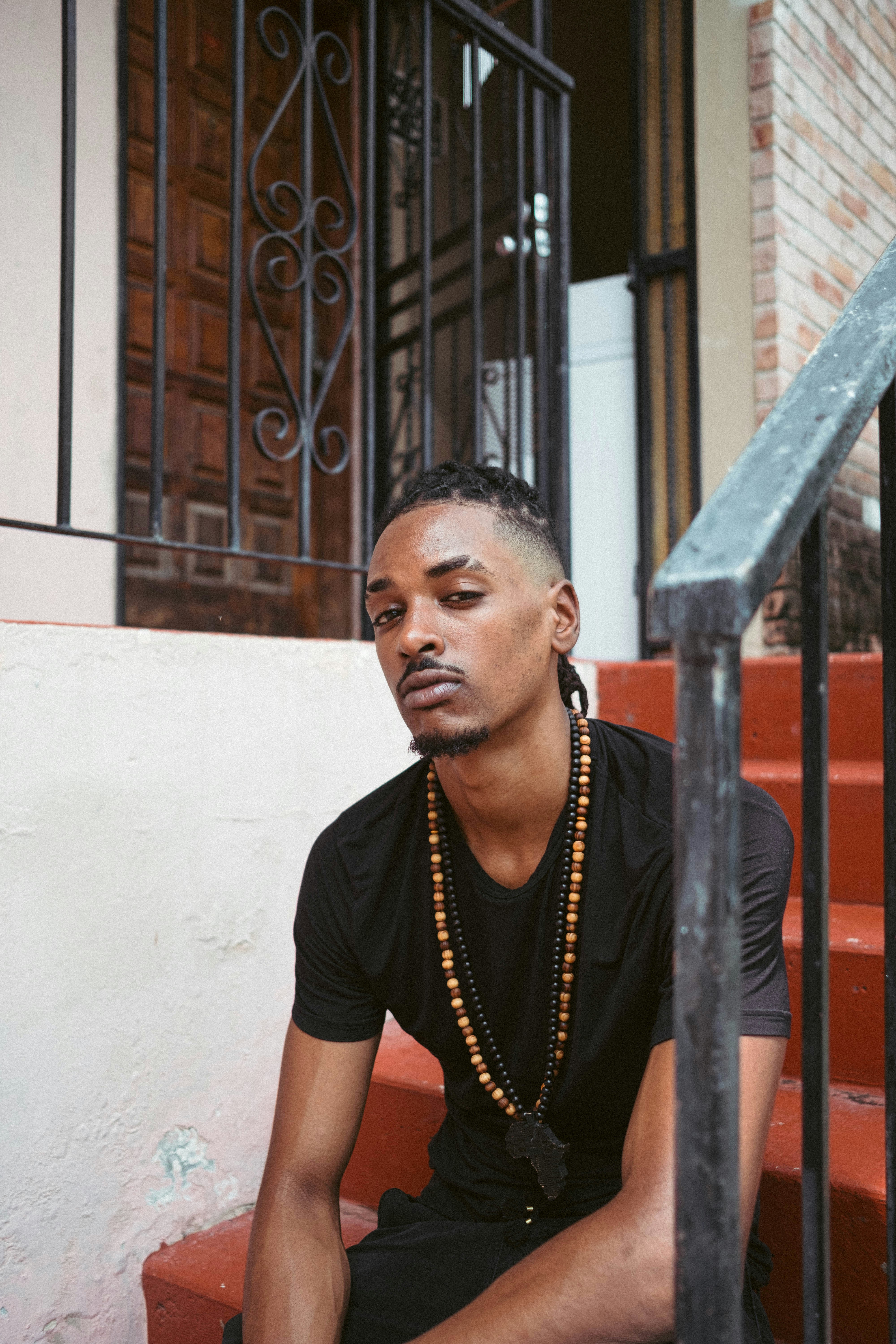 man in black crew neck t-shirt sitting on brown wooden bench