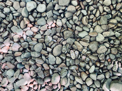 Close-up of smooth white river stones arranged in a garden setting.