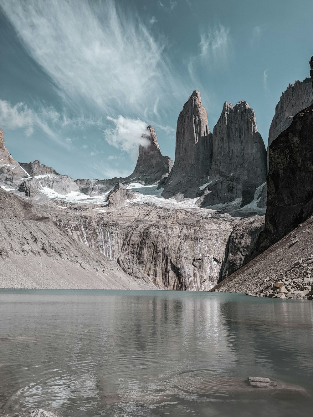 Montaña marrón y blanca cerca del cuerpo de agua durante el día