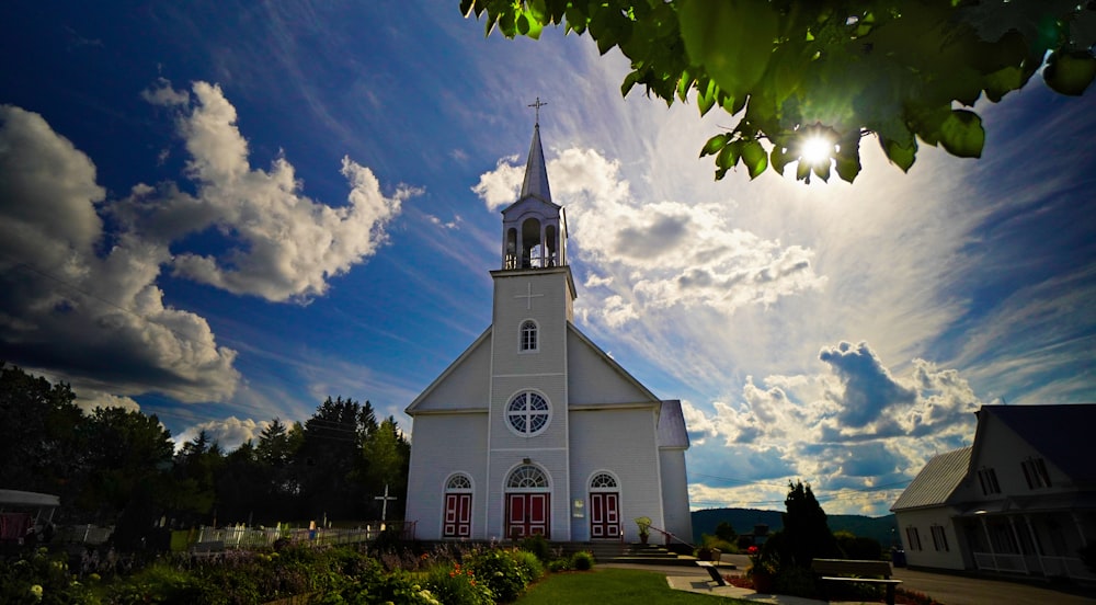 weiße Betonkirche unter blauem Himmel und weißen Wolken tagsüber