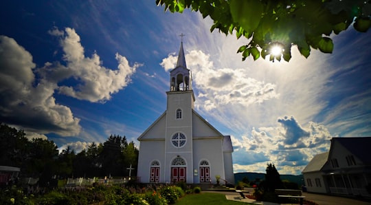 white concrete church under blue sky and white clouds during daytime in Saint-Zénon Canada