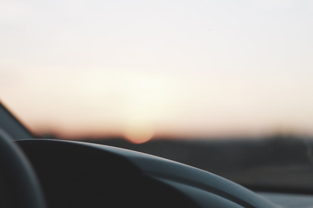 black car steering wheel during sunset