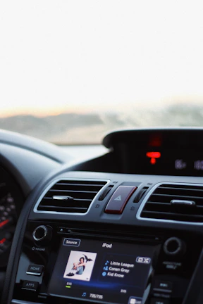 Colorful car dashboard decorated with Ototo stickers and a smartphone playing the playlist