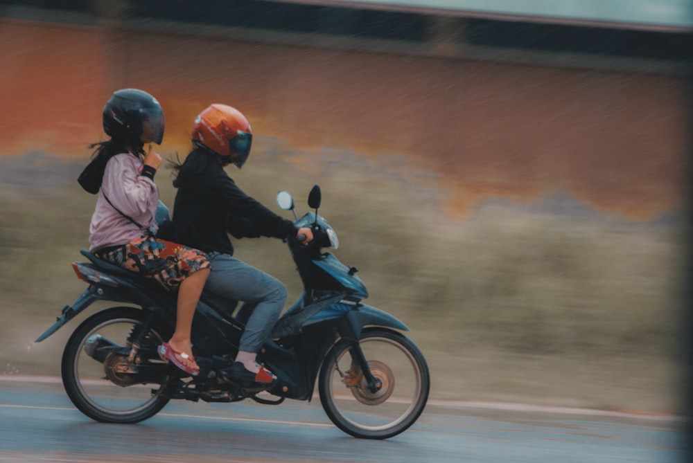 2 men riding motorcycle on road during daytime