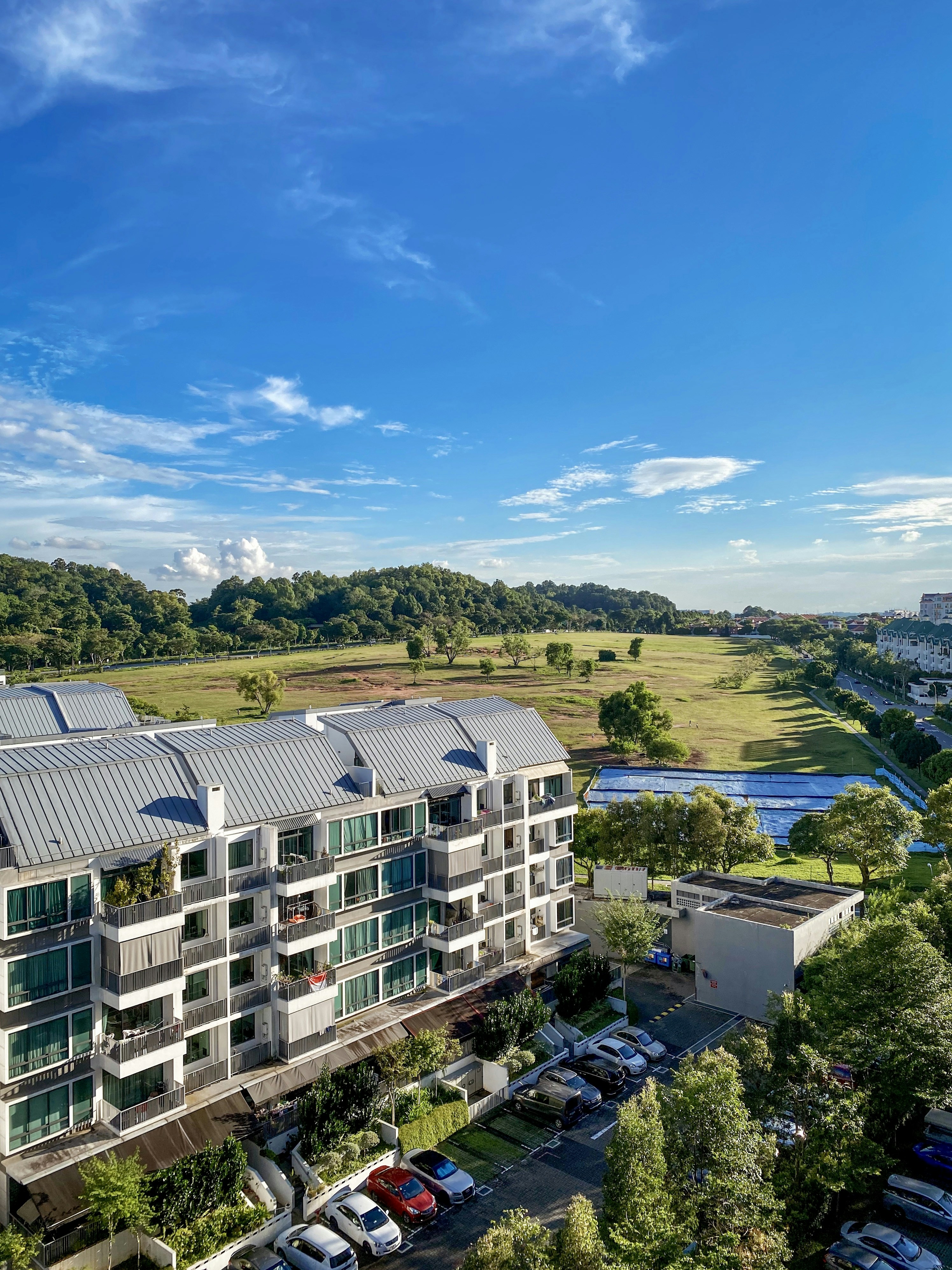 white concrete building near green trees under blue sky during daytime