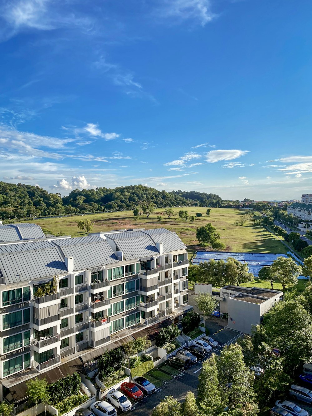 white concrete building near green trees under blue sky during daytime