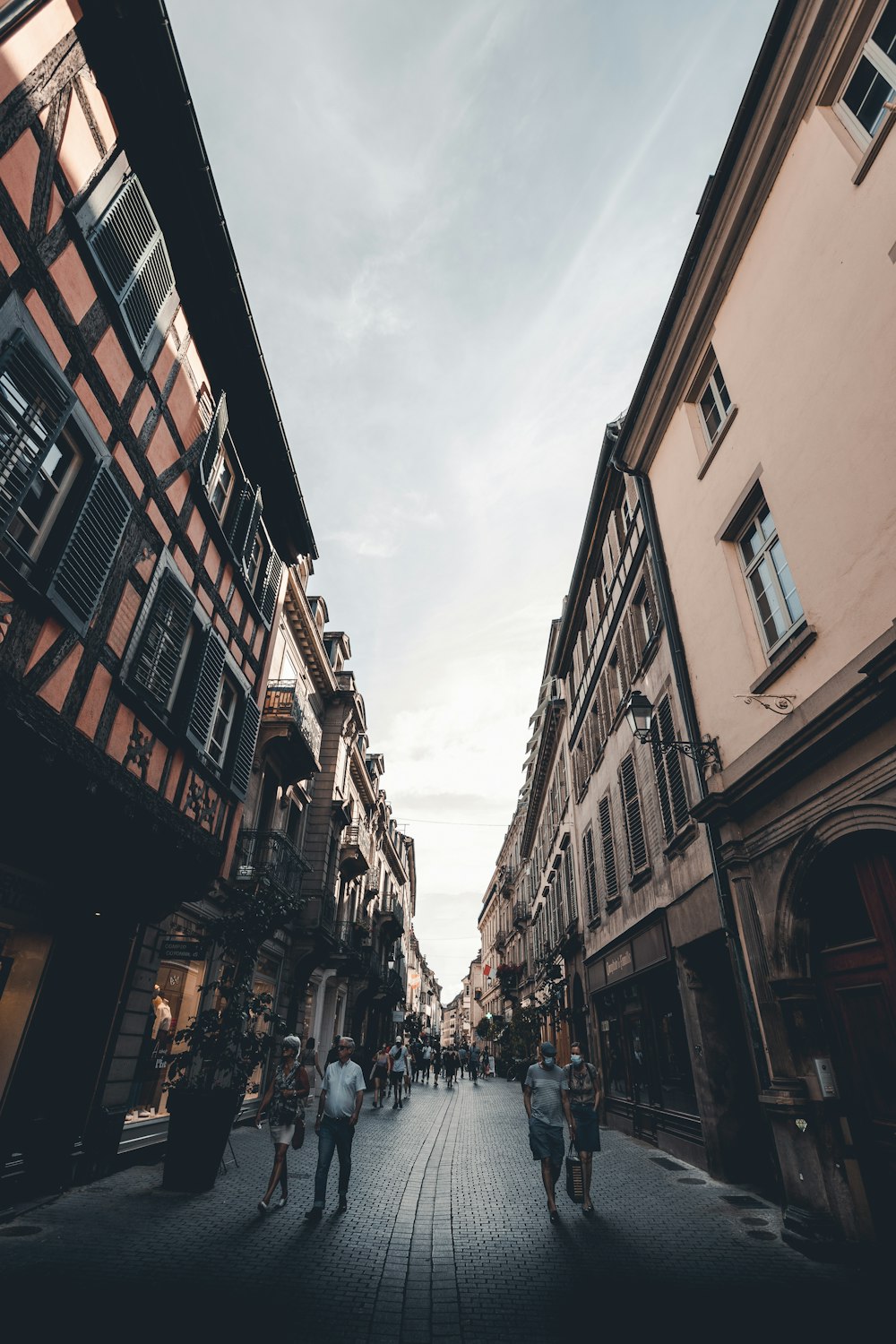 people walking on street between buildings during daytime