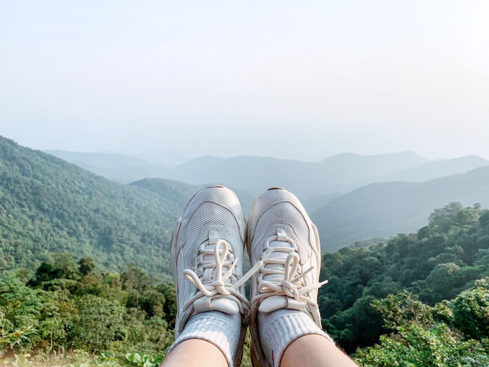 person wearing white lace up sneakers