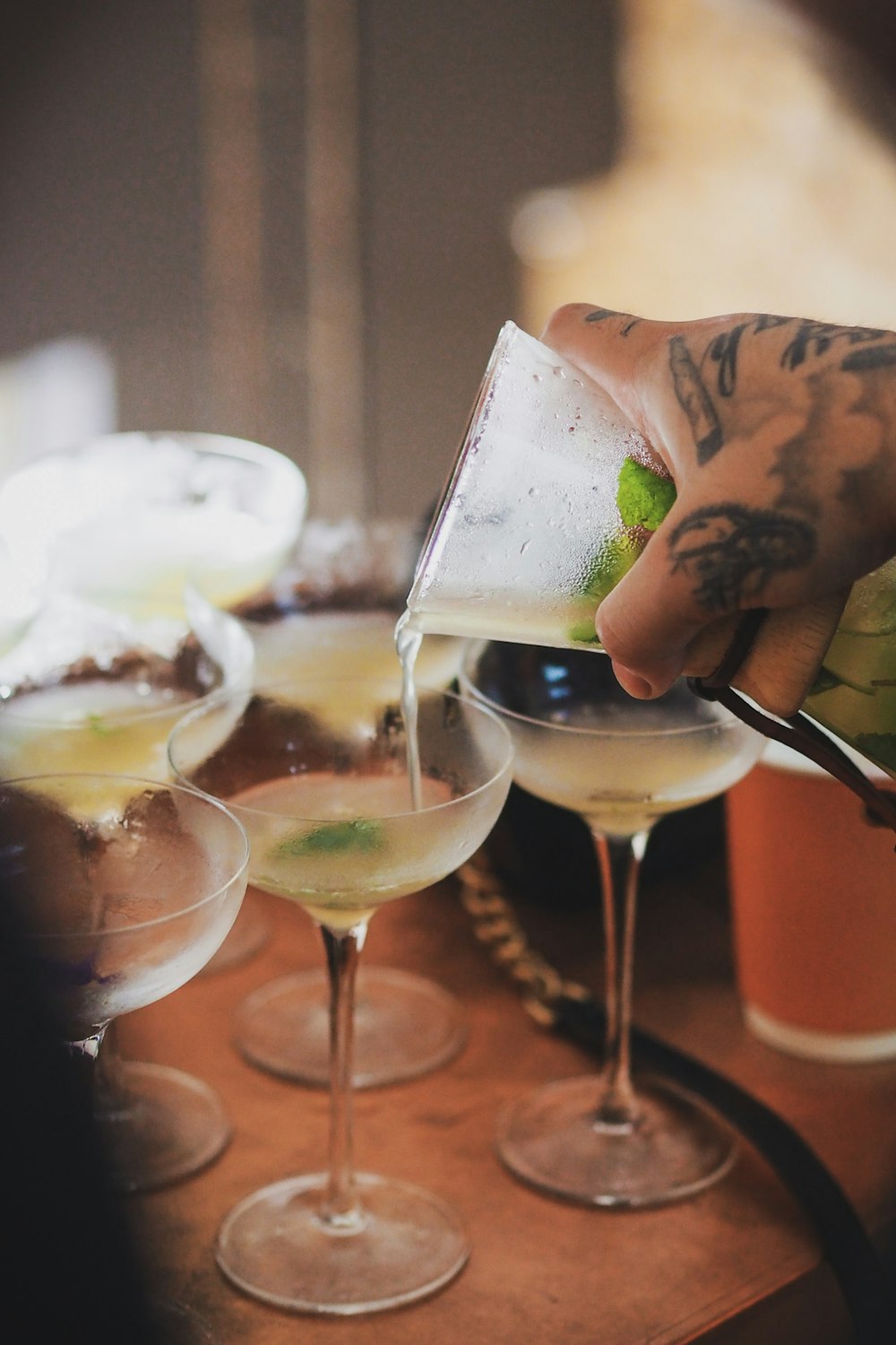 person pouring beverage on clear wine glass