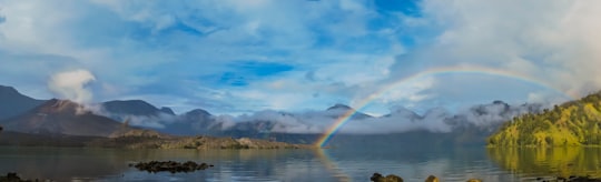 body of water under blue sky and white clouds during daytime in Mount Rinjani Indonesia