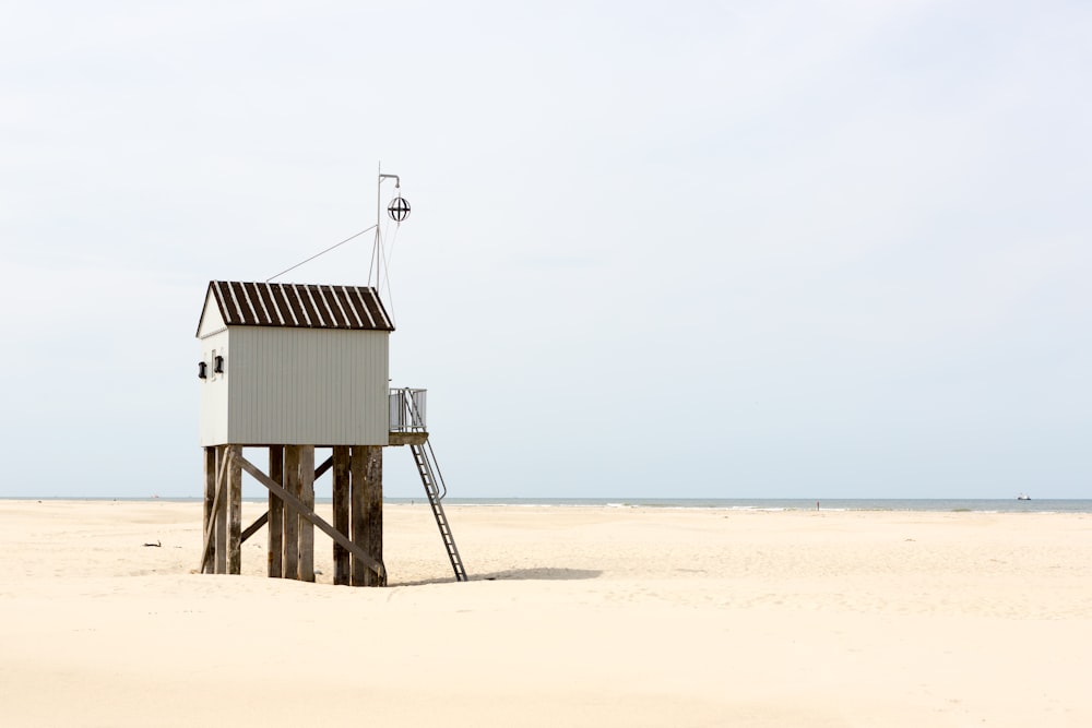 brown wooden lifeguard house on beach during daytime