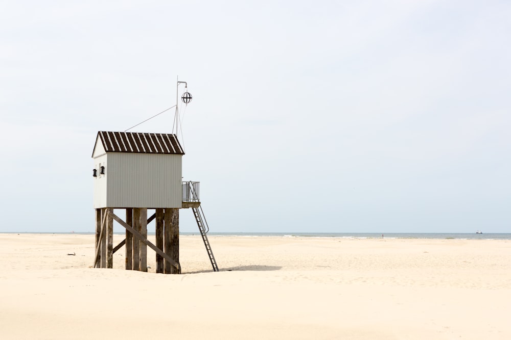 maison de sauveteur en bois marron sur la plage pendant la journée