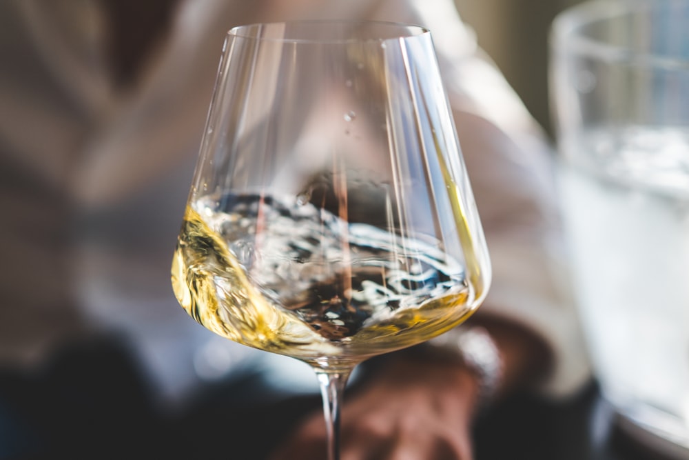 copo de vinho transparente com líquido amarelo