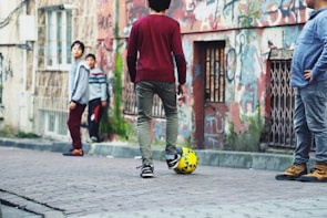 Children playing soccer on the rough field amid ongoing renovations, symbolizing hope for the future.