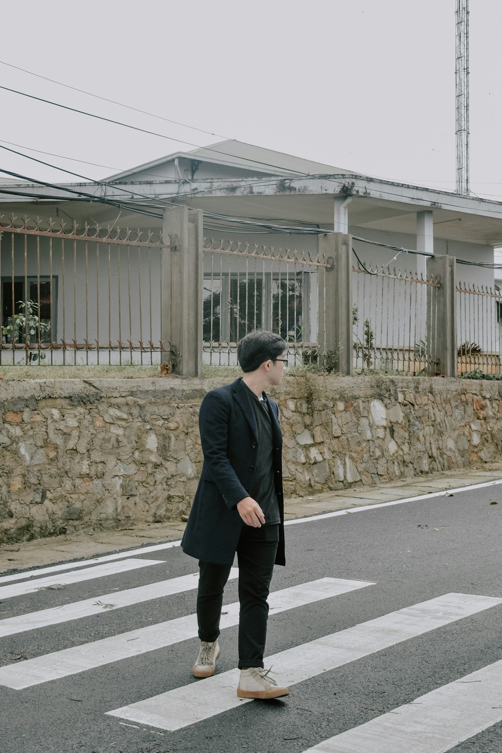 man in black coat standing on gray concrete pavement during daytime