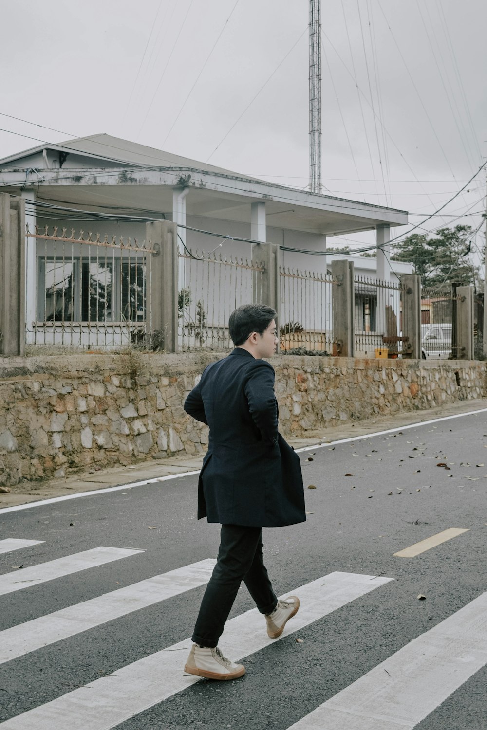 man in black coat standing on pedestrian lane during daytime