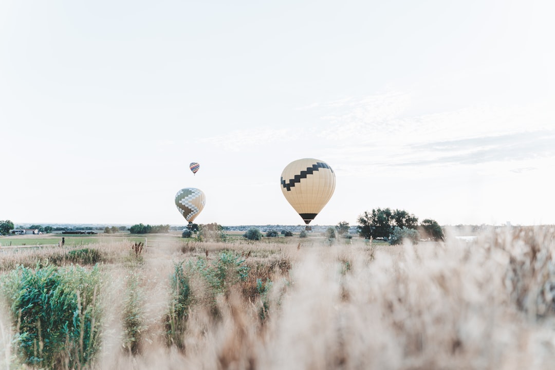 hot air balloon floating over the lake during daytime