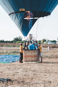 A hot air balloon preparing for takeoff in a green alpine meadow.