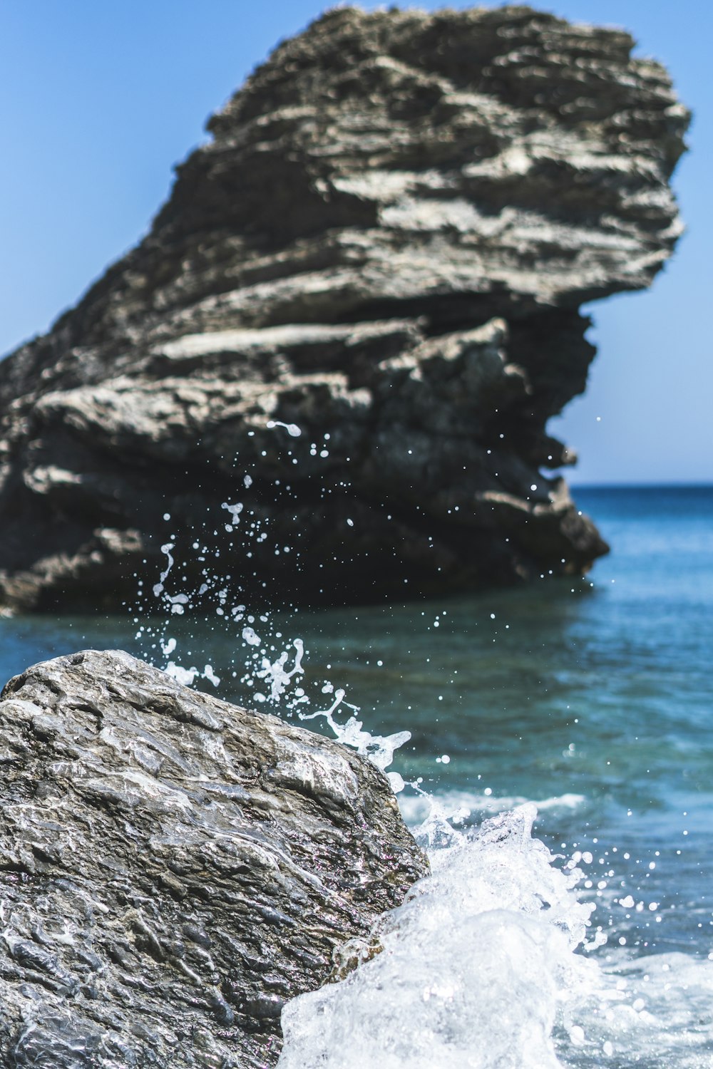 brown rock formation near body of water during daytime