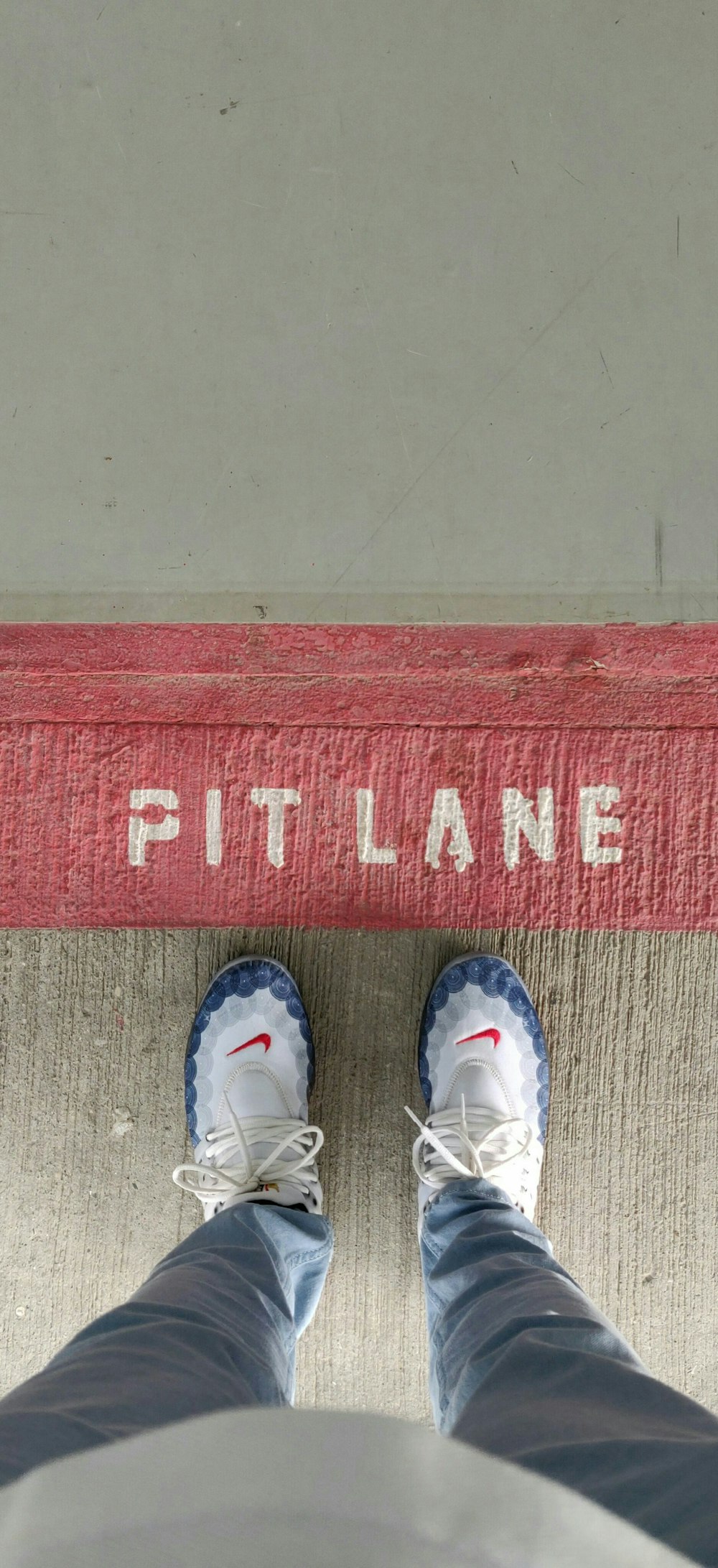 person wearing white shoes standing on red and brown area rug