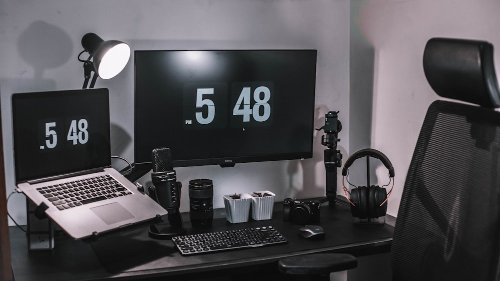 black flat screen computer monitor on black wooden desk