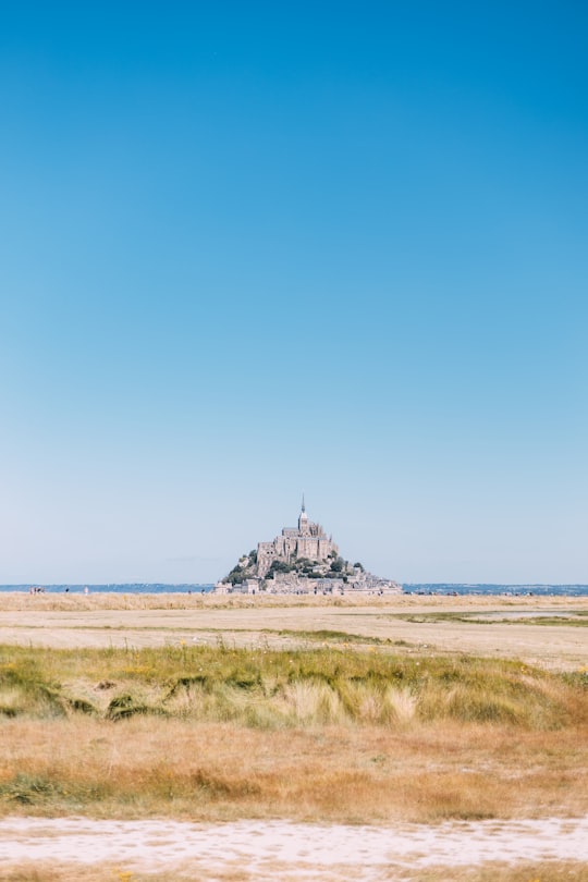 gray concrete building near body of water during daytime in Mont Saint-Michel France