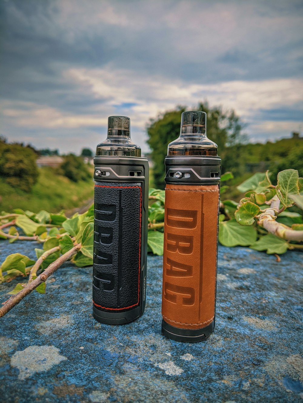 two orange and black bottles on gray concrete floor