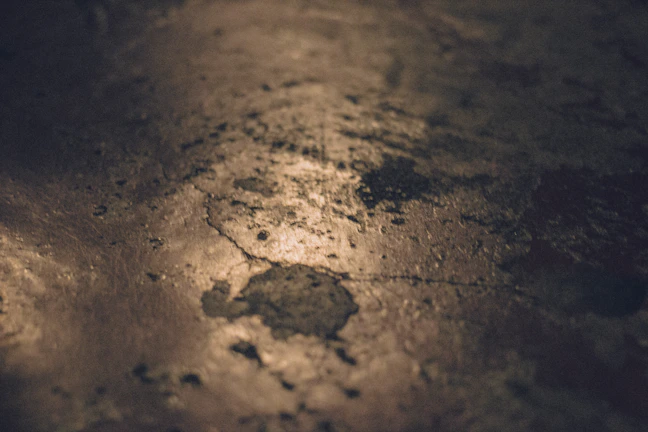 Close-up of raw clay texture with natural grains visible under warm light.