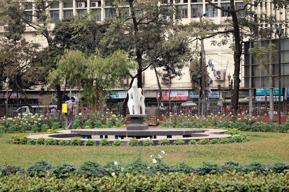 green grass field with trees and white statue