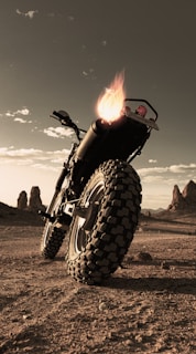 A stunning Ducati Desert X parked against the backdrop of the Sahara Desert.