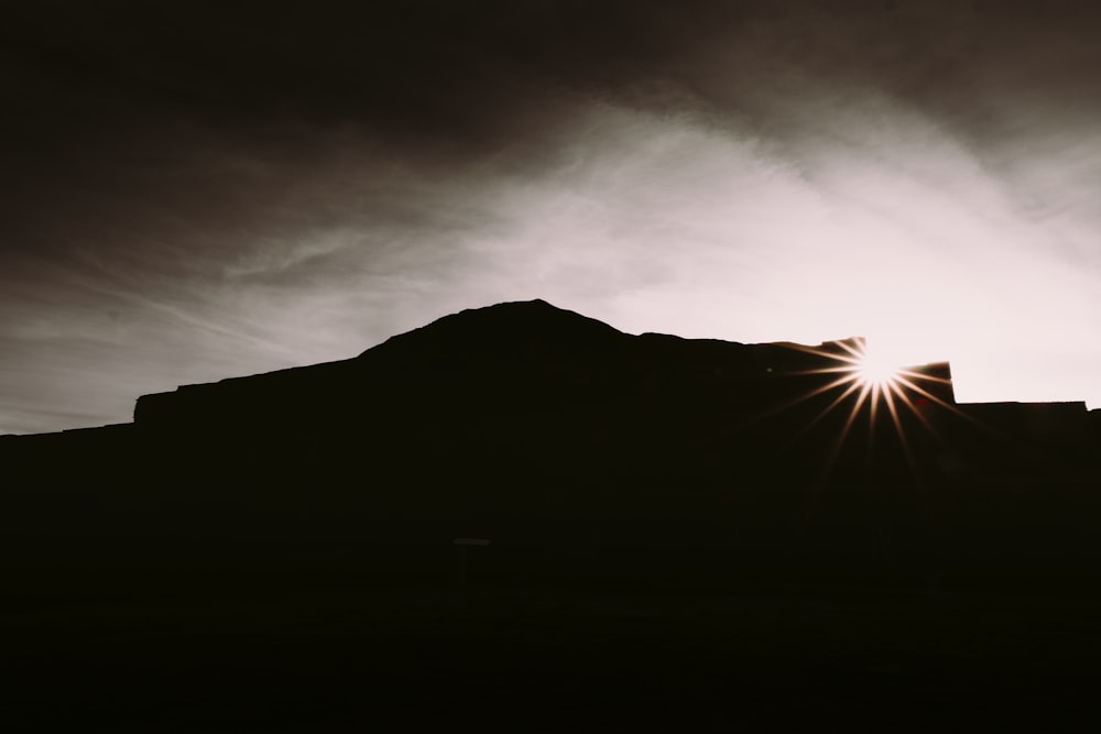 silhouette of mountain under white clouds during daytime