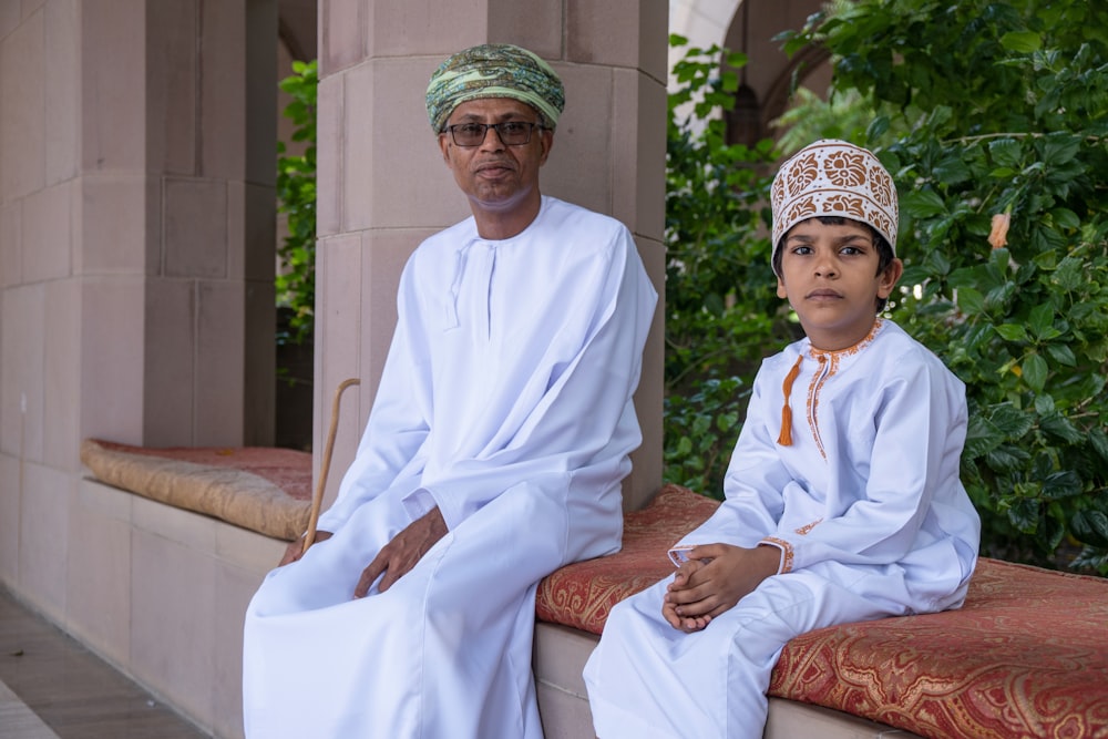 a man and a boy are sitting on a ledge