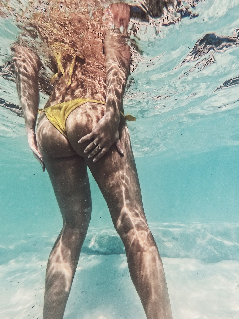 woman in yellow bikini in water