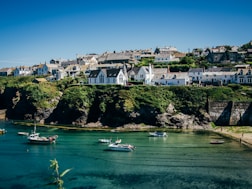 white and green boat on water near white concrete building during daytime