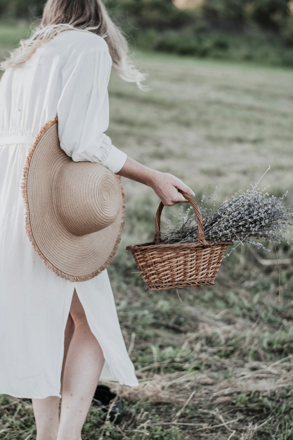 woman in white dress holding brown woven basket
