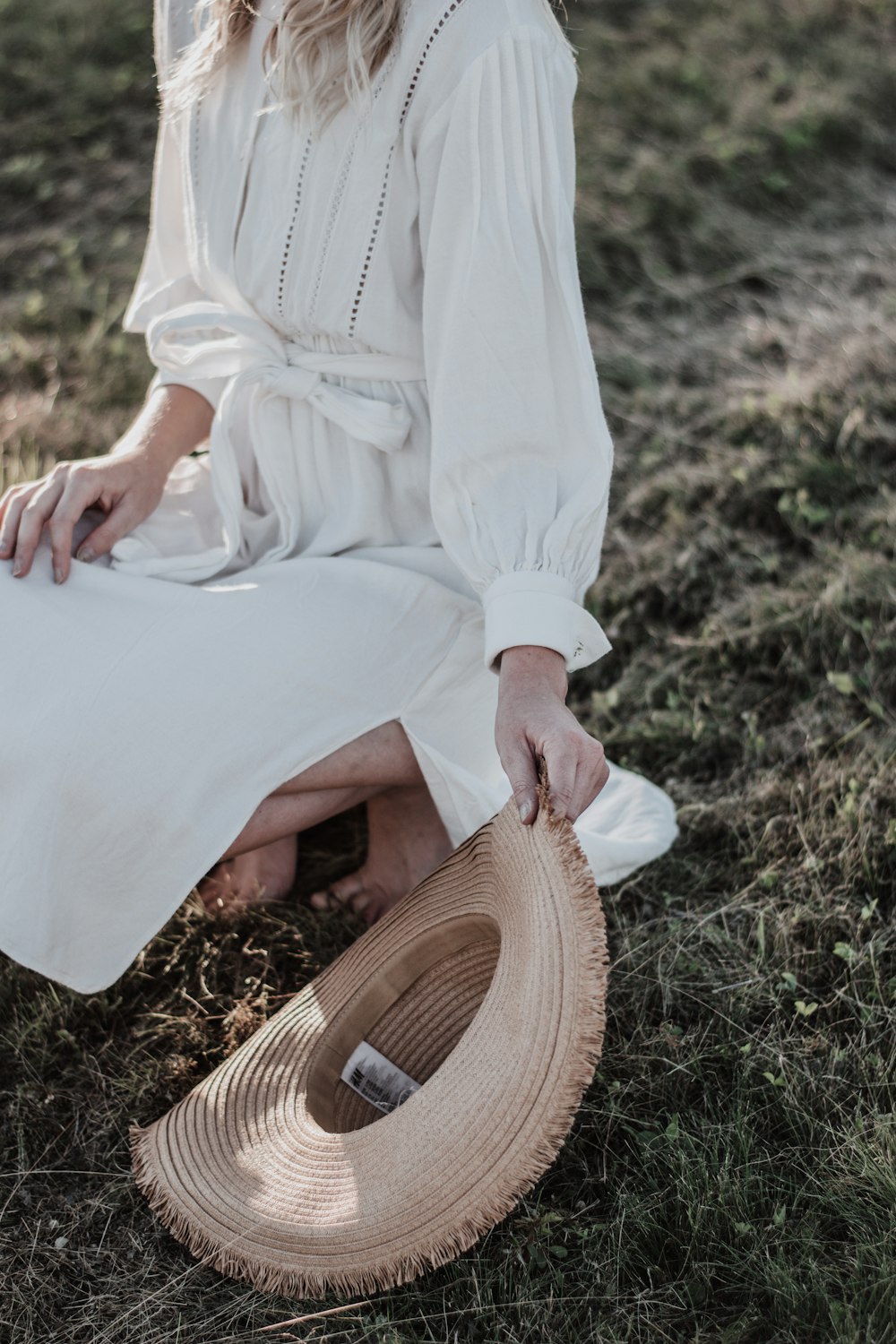 woman in white long sleeve dress sitting on brown wooden seat