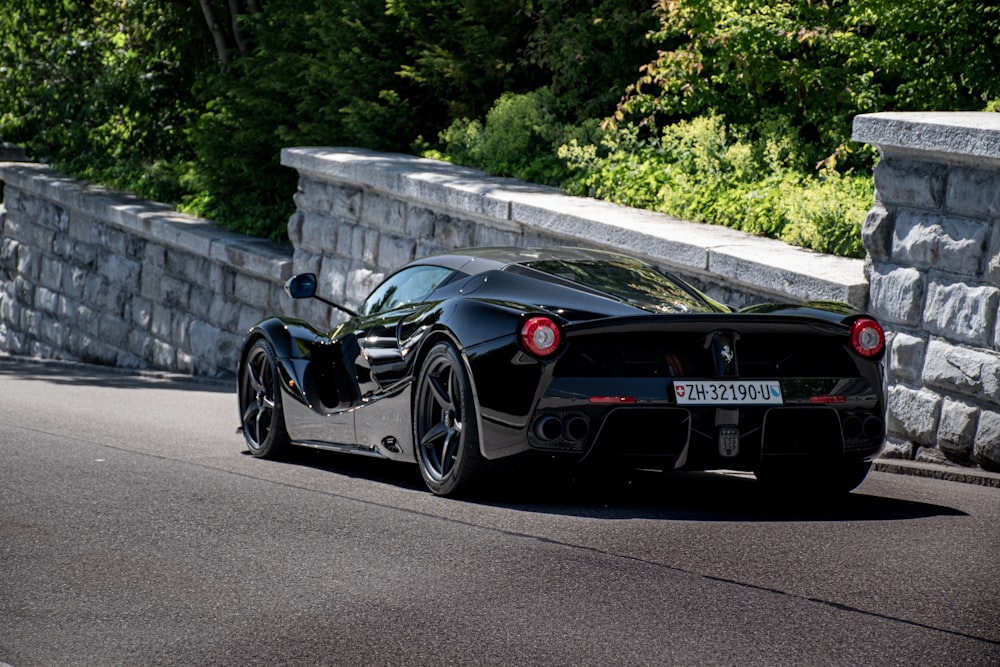 Porsche 911 nera parcheggiata su un marciapiede di cemento grigio