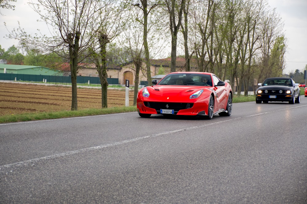 red ferrari sports car on road during daytime