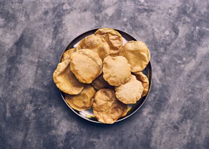 Close-up of crispy urad papad stacked neatly on a rustic wooden board.
