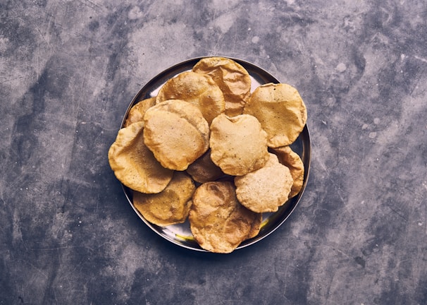 Close-up of golden stuffed paranthas stacked on a rustic wooden board.