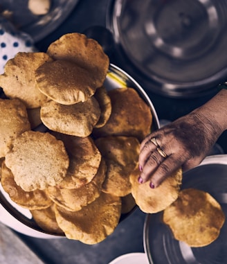 person holding brown cookies on blue and white ceramic plate