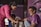 man in purple shirt and gray pants sitting on floor