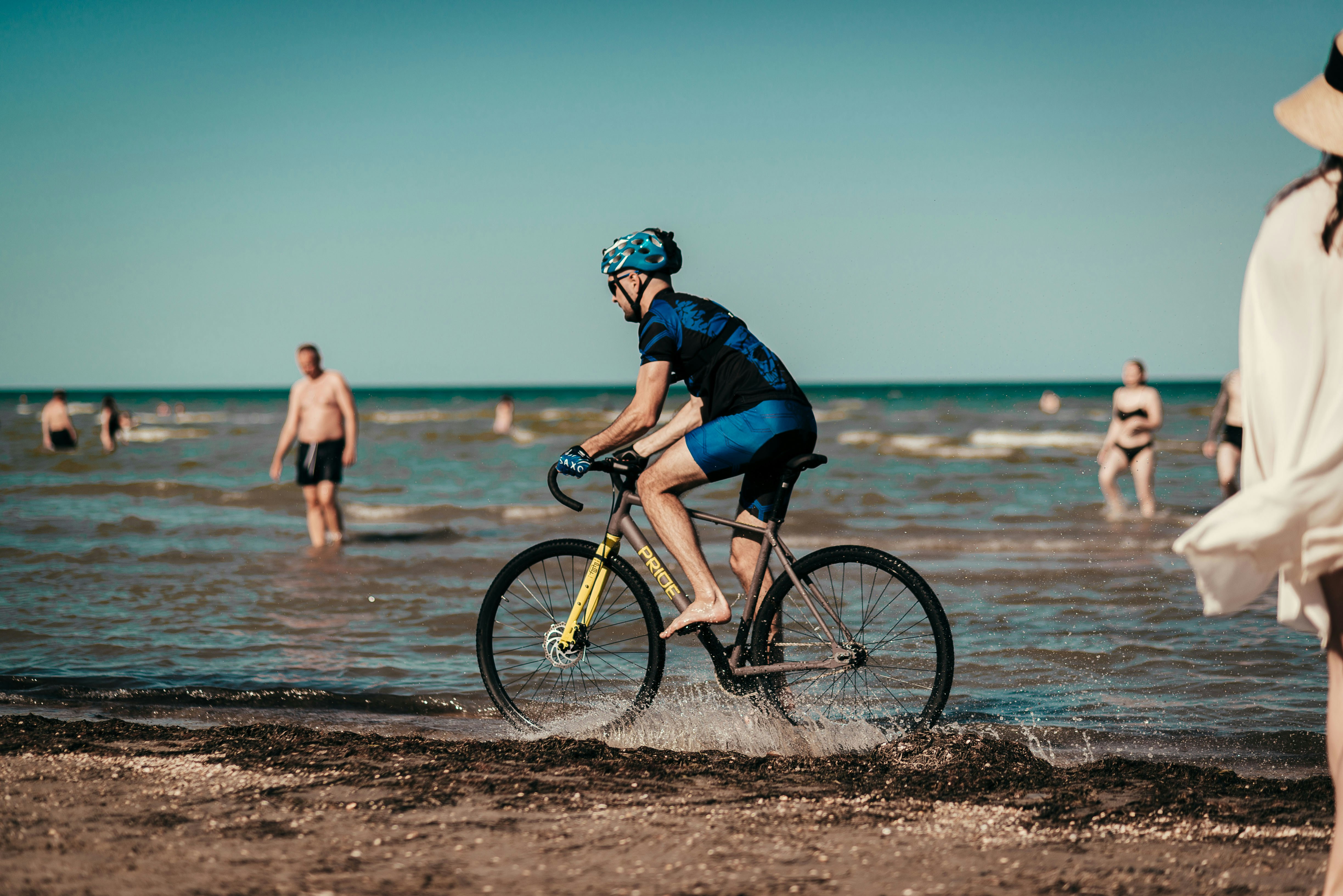 man in black jacket riding on bicycle on beach during daytime