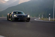 Dynamic shot of a Skyline GTR accelerating through a winding mountain road at dusk.