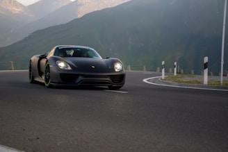 A sleek car fitted with shiny GT tires driving on a mountain road
