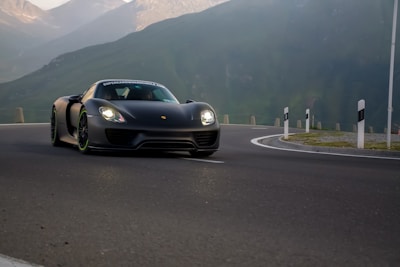 A sleek car fitted with shiny GT tires driving on a mountain road