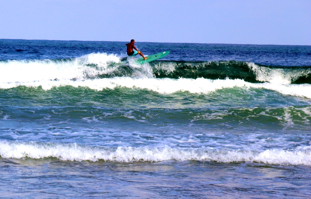 hombre surfeando en las olas del mar durante el día