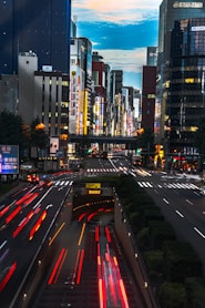 cars on road near high rise buildings during night time