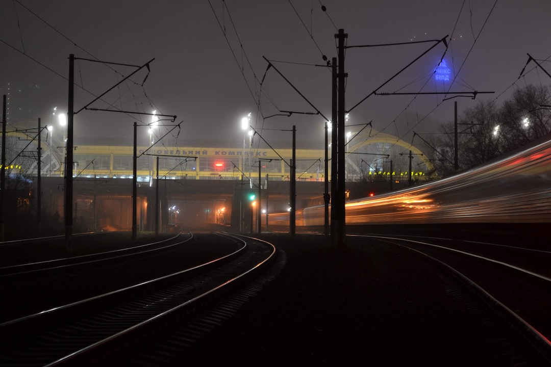 time lapse photography of cars on road during night time, Train rushes through the night fog