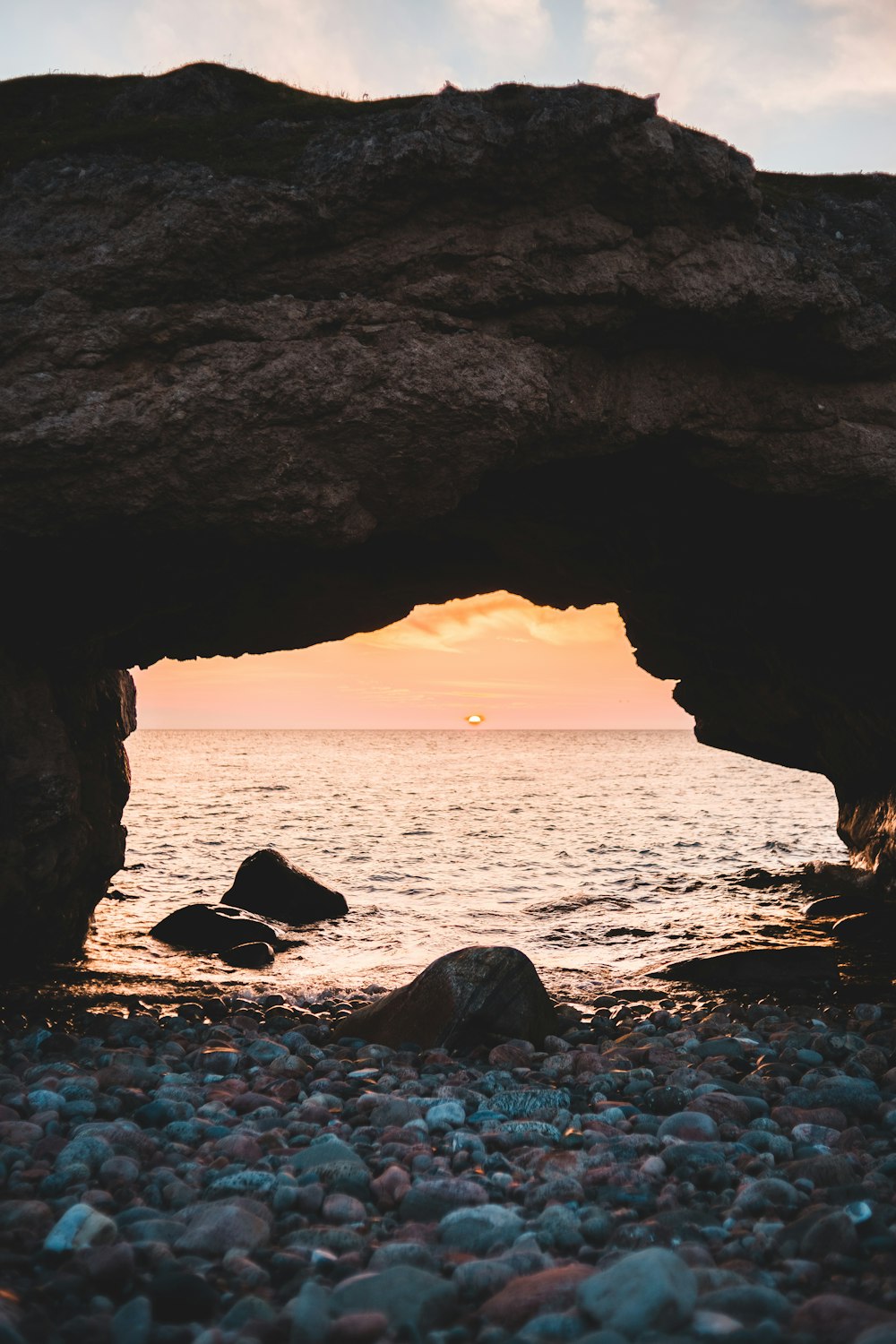 brown rock formation on sea during sunset